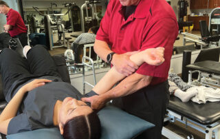 Image of physical therapist examining a woman's shoulder