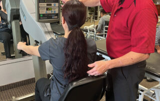 Image of physical therapist providing instruction on a physical therapy machine