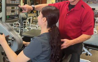 Image of physical therapist providing instruction on a physical therapy machine